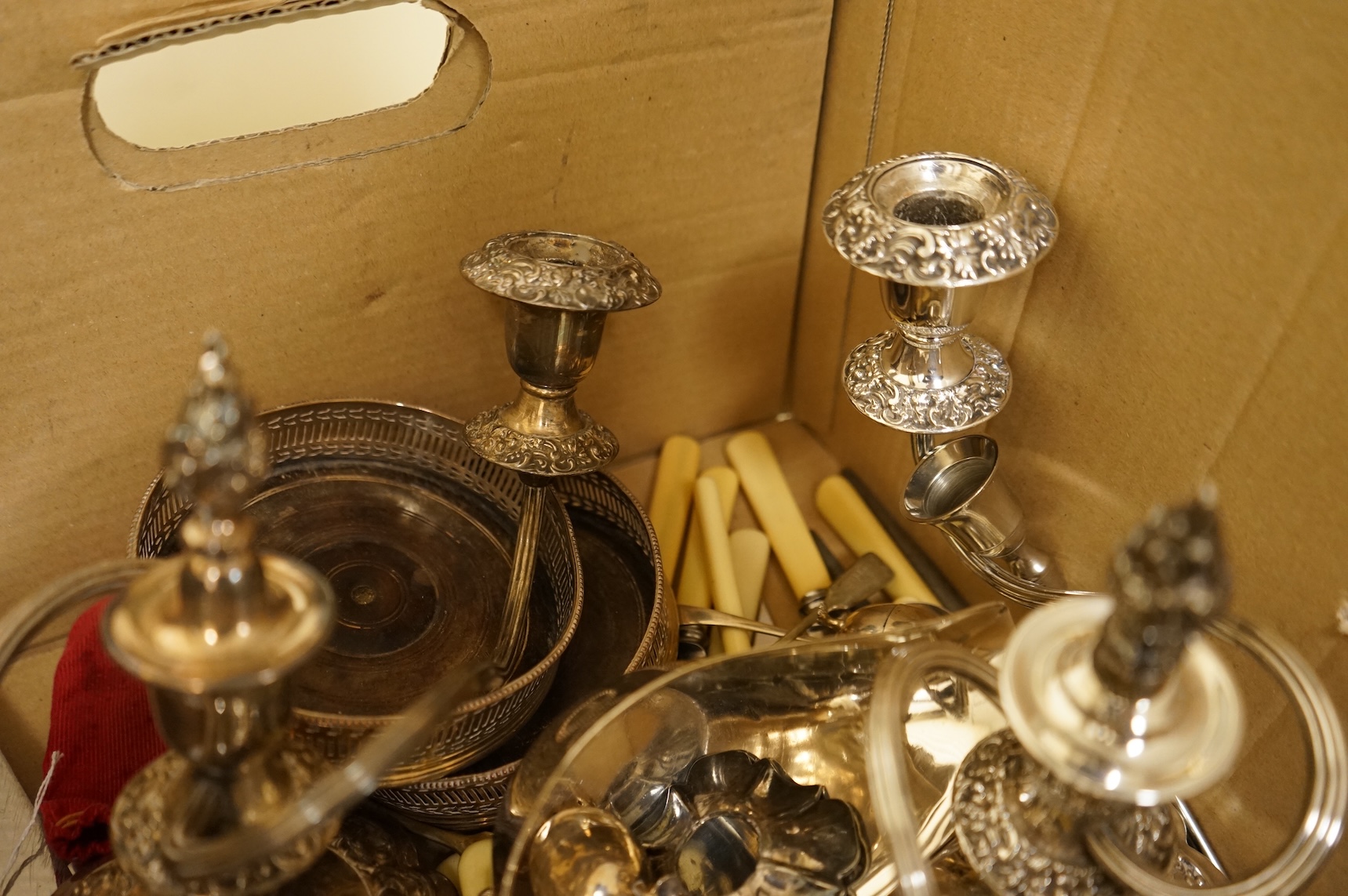 A group of sundry plated items including dwarf candelabra, a pair of wine coasters, a pair of grape shears, etc., and a quantity of assorted ivorine handled table and dessert knives.